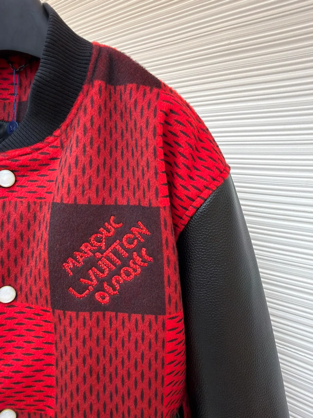 LOUIS VUITTON Plaid Logo Letter Beaded Embroidery Jacket ●Original version: Purchased and developed by 45646 ●Item number: 1681758-B95 ●Fabric: wool blended fabric ●Technology: Beaded embroidery production ●Color: red and black plaid ●Version: Fitted version ●Weight: about 1250 grams ●Size: 46-48-50-52 ●Description: The main body is made of contrasting plaid knitted fabric, with texture levels created through jacquard weaving technology. It is soft to the touch and has a crisp silhouette; the sleeves are spliced with matte leather and treated with scratch-resistant and wear-resistant treatment, giving it both texture and durability. The body of the garment is decorated with the brand's letter logo, using three-dimensional embroidery technology, with bright colors and clear texture to enhance recognition. The version is designed with a fitted baseball collar and is equipped with pearl button closure, making it easy to put on and take off. The ribbed collar, cuffs and hem enhance the fit and take into account windproofness and casual feel. The splicing of the whole garment adopts precision locking technology, with no exposed threads, and the size is measured manually (an error of 1-3CM is normal). The craftsmanship balances the softness of knitting and the toughness of leather, presenting the brand's trendy and advanced style. The overall wiring is straight and delicate, the fabric is comfortable and soft, and the color is consistent without color difference. It can be matched with the same style to create a fashionable look and control various occasions. Customized accessories, complete with three standards, same style for men and women!